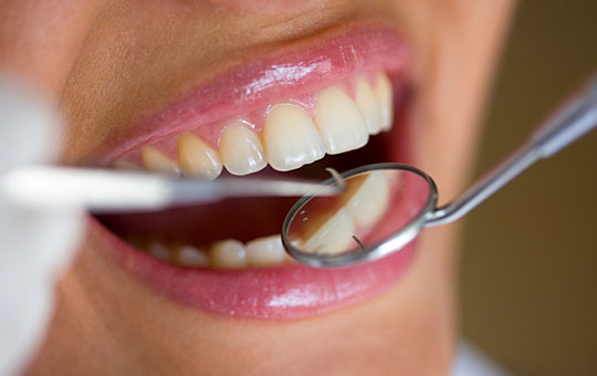 A woman having her teeth examined by a dentist